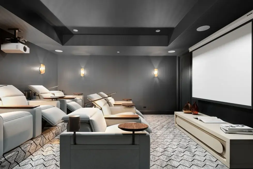 Basement theatre with reclining seats, a projection screen and a dark tray ceiling